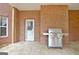 Covered patio area featuring an outdoor grill, a white door, and a brick wall backdrop at 165 Hideaway Dr, Fayetteville, GA 30215