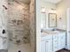 Beautiful bathroom featuring double sinks, granite countertops, and a stunning tiled shower with a built-in niche at 217 Point Ridge Ct, Temple, GA 30179