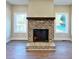 Close up of a brick fireplace with a wood mantle, flanked by windows at 217 Point Ridge Ct, Temple, GA 30179