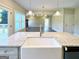 Kitchen island featuring granite countertops and a farm-style sink overlooking the living room fireplace at 217 Point Ridge Ct, Temple, GA 30179