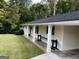 Inviting home exterior featuring a brick accent, covered parking area, and well-maintained landscaping at 497 Pine Haven Ln, Atlanta, GA 30342