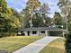 Charming single-story home with a well-manicured lawn and a long driveway leading up to the entrance at 497 Pine Haven Ln, Atlanta, GA 30342