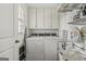 Well-lit laundry room with washer, dryer, shelving, and storage cabinets at 497 Pine Haven Ln, Atlanta, GA 30342