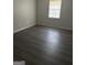 Bedroom with modern wood-look flooring and a window providing natural light, complemented by fresh, neutral paint at 6540 Lower Dixie Lake Rd, Union City, GA 30291
