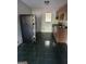 Well-lit kitchen features a black refrigerator, dark tile flooring, wooden cabinets and a stainless steel sink at 6540 Lower Dixie Lake Rd, Union City, GA 30291