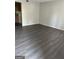 Spacious living room features gray walls and new wood-look floors, with an adjacent kitchen area at 6540 Lower Dixie Lake Rd, Union City, GA 30291