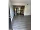 View from doorway into living room with wood-look floors and a glimpse into the kitchen with black appliances at 6540 Lower Dixie Lake Rd, Union City, GA 30291