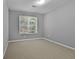 Calm bedroom with neutral paint, carpet, and window offering views of the outdoors at 115 Brook Hollow Dr, Mcdonough, GA 30252