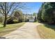 Inviting home features a long driveway, two-car garage, and a well-maintained front lawn surrounded by trees at 115 Brook Hollow Dr, Mcdonough, GA 30252