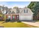 Charming two-story home featuring a brick facade, dormer windows, and an attached two-car garage at 115 Brook Hollow Dr, Mcdonough, GA 30252