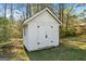 Classic backyard shed with white painted wood, black door hardware and a classic gabled roof at 115 Brook Hollow Dr, Mcdonough, GA 30252