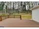 A wood deck overlooks a spacious backyard with mature trees and a wooden fence at 5155 Rosestone Nw Dr, Lilburn, GA 30047