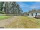 A large backyard features an expansive grassy area, a wooden fence, and the exterior of the home at 5155 Rosestone Nw Dr, Lilburn, GA 30047