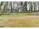 A expansive, private backyard bordered by mature trees and a wooden fence at 5155 Rosestone Nw Dr, Lilburn, GA 30047