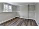 Finished basement space with dark wood-look floors, wainscoting and natural light from a window at 5155 Rosestone Nw Dr, Lilburn, GA 30047