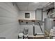 A gray cabinet sits above a wood shelf in a basement with white shiplap walls and water heater at 5155 Rosestone Nw Dr, Lilburn, GA 30047