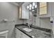 Bathroom featuring granite countertop, white cabinets, mirror, modern lighting, and a view of the tiled shower at 5155 Rosestone Nw Dr, Lilburn, GA 30047