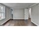 Bedroom with hardwood floors, neutral walls, white trim, and two entry doors at 5155 Rosestone Nw Dr, Lilburn, GA 30047