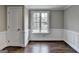 A vacant, light-filled room showcasing pristine white trim, wainscoting, and hardwood floors that complement the neutral walls at 5155 Rosestone Nw Dr, Lilburn, GA 30047