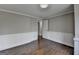 An airy, vacant room with hardwood floors, white trim, and neutral walls, illuminated by natural light through a window at 5155 Rosestone Nw Dr, Lilburn, GA 30047