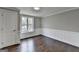 A vacant, light-filled room showcasing pristine white trim, wainscoting, and hardwood floors that complement the neutral walls at 5155 Rosestone Nw Dr, Lilburn, GA 30047