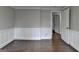 An airy, vacant room with hardwood floors, white trim, and neutral walls, illuminated by natural light through a window at 5155 Rosestone Nw Dr, Lilburn, GA 30047