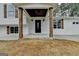 Inviting front porch with wood columns and a black front door enhance the home's curb appeal at 5155 Rosestone Nw Dr, Lilburn, GA 30047