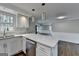 A close view of the kitchen island with white veined countertop, pendant lights and stainless steel dishwasher at 5155 Rosestone Nw Dr, Lilburn, GA 30047