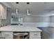 Modern kitchen island featuring a waterfall countertop, stainless steel appliances, and designer pendant lighting at 5155 Rosestone Nw Dr, Lilburn, GA 30047