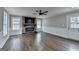 Spacious living room boasts a stone fireplace, hardwood floors, ample natural light, and modern ceiling fan at 5155 Rosestone Nw Dr, Lilburn, GA 30047
