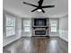 Bright living room with a modern stone fireplace, hardwood floors, and updated ceiling fan fixture at 5155 Rosestone Nw Dr, Lilburn, GA 30047