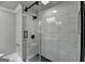 Luxurious glass-enclosed shower featuring black hardware, marble tiling, and a modern shower head at 5155 Rosestone Nw Dr, Lilburn, GA 30047