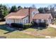 Charming two-story home with brick chimney, manicured lawn, and mature trees at 105 Overlook Dr, Mcdonough, GA 30252