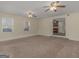 Spacious living room with a ceiling fan, multiple windows, and an opening to the kitchen at 105 Overlook Dr, Mcdonough, GA 30252