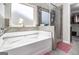 Bathroom boasts a soaking tub and glass-enclosed shower, illuminated by a window for a spa-like experience at 1734 Tricklin Spgs, Mcdonough, GA 30252