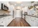 Modern kitchen with white cabinetry, stainless steel appliances, and hardwood floors, perfect for cooking enthusiasts at 1734 Tricklin Spgs, Mcdonough, GA 30252