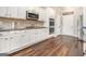 Well-lit kitchen with white cabinets, stainless steel appliances, and hardwood flooring at 1734 Tricklin Spgs, Mcdonough, GA 30252