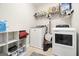 Neat laundry room equipped with a modern washer and dryer, shelves, and tile floors at 1734 Tricklin Spgs, Mcdonough, GA 30252