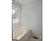 Bathtub in the bathroom with tile floors, neutral paint, and window for natural light at 89 Farm Brook Ln # 17, Dallas, GA 30157