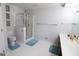 Clean bathroom with a glass shower, white tiled walls, and turquoise rugs at 237 Summerford Pl, Stockbridge, GA 30281