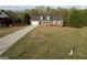 Aerial view of a brick home with a large front yard, two-car garage, and a cozy front porch at 237 Summerford Pl, Stockbridge, GA 30281