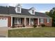 Classic brick home with white-columned front porch and rocking chairs offers a cozy curb appeal at 237 Summerford Pl, Stockbridge, GA 30281