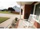 Well-kept front porch of brick home with rocking chair overlooking lush landscaping at 237 Summerford Pl, Stockbridge, GA 30281