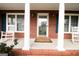 Welcoming front porch with rocking chairs flanked by white columns and manicured garden beds at 237 Summerford Pl, Stockbridge, GA 30281