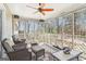 Spacious sunroom featuring multiple chairs and a ceiling fan with views of the wooded backyard at 375 Wellington Mill Rd, Whitesburg, GA 30185