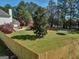 Large, fenced backyard featuring mature trees, a trampoline, and a wooden deck perfect for outdoor entertaining at 720 Strawflower Ln, Locust Grove, GA 30248