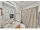 Neutral bathroom featuring a shower with patterned curtain, vanity, artwork, and towel rack at 720 Strawflower Ln, Locust Grove, GA 30248