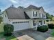 Charming house featuring a two-car garage, well-maintained lawn, and a cozy front porch perfect for relaxing at 720 Strawflower Ln, Locust Grove, GA 30248