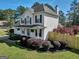 Two-story house with white siding, dark shutters, a cozy front porch, and professionally landscaped front yard at 720 Strawflower Ln, Locust Grove, GA 30248