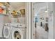 Neat laundry room features white washer and dryer, shelving, and doorway leading to main bedroom at 720 Strawflower Ln, Locust Grove, GA 30248